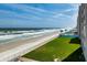 Scenic beach view showcasing the ocean, beach, pool, and green lawn at 4495 S Atlantic Ave # 5020, Ponce Inlet, FL 32127