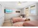 Cozy bedroom featuring two twin beds, a ceiling fan, and shuttered windows at 4495 S Atlantic Ave # 5020, Ponce Inlet, FL 32127