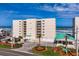 Condominium building exterior featuring a large green awning, beach access and palm trees at 4495 S Atlantic Ave # 5020, Ponce Inlet, FL 32127