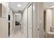 Bright hallway with white doors leading to a bathroom with tub and shower at 4495 S Atlantic Ave # 5020, Ponce Inlet, FL 32127