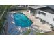 Aerial view shows a sparkling pool next to white brick building with gray-screened porch at 48 Carriage Hill Cir, Casselberry, FL 32707