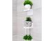 Charming bathroom decor with decorative potted plants arranged on white shelves, adding a whimsical touch at 502 Summer Place Loop, Clermont, FL 34714