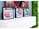 A modern decor featuring framed superhero art, a sleek white console, and a vibrant green wall plant at 502 Summer Place Loop, Clermont, FL 34714