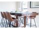 Stylish dining area with a glass-topped table, comfortable barstool seating, and bright natural light at 502 Summer Place Loop, Clermont, FL 34714