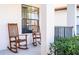 Inviting front porch featuring wooden rocking chairs, offering a relaxing outdoor seating area at 502 Summer Place Loop, Clermont, FL 34714