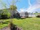 A green backyard with a screened patio and privacy fence on a sunny day at 527 Buckhaven Loop, Ocoee, FL 34761