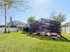 Landscaped backyard with a screened-in patio with outdoor seating and lush green grass at 527 Buckhaven Loop, Ocoee, FL 34761