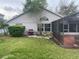 Home exterior featuring a screened-in patio, grill, tidy yard, and landscaping, creating an inviting outdoor space at 527 Buckhaven Loop, Ocoee, FL 34761