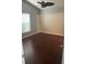 A clean, empty room with hard wood floors, a ceiling fan, and a window at 527 Buckhaven Loop, Ocoee, FL 34761