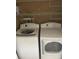 Convenient laundry area with white front load washer and dryer set and wire shelving storage at 527 Buckhaven Loop, Ocoee, FL 34761