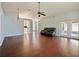 Spacious living room with hardwood floors, neutral wall paint, modern ceiling fan, and natural lighting at 527 Buckhaven Loop, Ocoee, FL 34761