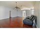 Open-concept living room featuring hardwood floors, light gray walls, and a contemporary ceiling fan at 527 Buckhaven Loop, Ocoee, FL 34761