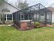 Covered screened patio area with outdoor seating, next to the home and well-maintained lawn at 527 Buckhaven Loop, Ocoee, FL 34761