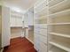 Organized walk-in closet with built-in shelving, and drawer units for efficient storage solutions at 527 Buckhaven Loop, Ocoee, FL 34761