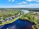 Aerial view of a lakeside community with homes featuring pools and spacious yards, offering picturesque scenery at 558 Osprey Lakes Cir, Chuluota, FL 32766