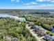 Aerial neighborhood view featuring houses, mature trees, and a tranquil lake with beautiful scenery at 558 Osprey Lakes Cir, Chuluota, FL 32766