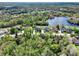 Aerial view of a neighborhood with houses surrounded by lush greenery and water features in a peaceful setting at 558 Osprey Lakes Cir, Chuluota, FL 32766