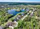 Neighborhood aerial view showcasing houses, a beautiful pond, and lush landscapes from a higher vantage point at 558 Osprey Lakes Cir, Chuluota, FL 32766