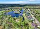 Stunning aerial view of a lakeside community with mature trees and well-maintained homes at 558 Osprey Lakes Cir, Chuluota, FL 32766