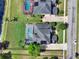 Aerial view of the property showcasing the pool, backyard, and proximity to neighboring houses and the street at 558 Osprey Lakes Cir, Chuluota, FL 32766