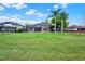 Expansive backyard with a large screened enclosure and mature palm trees enhancing privacy at 558 Osprey Lakes Cir, Chuluota, FL 32766