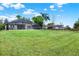 Sprawling backyard featuring a screened patio, lush green grass, and a classic wooden fence at 558 Osprey Lakes Cir, Chuluota, FL 32766