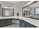 This bathroom offers double sinks, gray cabinets and large mirrors with access to the shower at 558 Osprey Lakes Cir, Chuluota, FL 32766