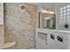 Elegant bathroom with a tiled shower, rainfall showerhead, and glass block window, complemented by stylish fixtures at 558 Osprey Lakes Cir, Chuluota, FL 32766