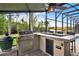 Outdoor kitchen with a built-in grill, counter space and views of the lake at 558 Osprey Lakes Cir, Chuluota, FL 32766