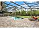 Inviting screened pool with an outdoor kitchen and lounge area perfect for entertaining and relaxation at 558 Osprey Lakes Cir, Chuluota, FL 32766