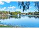 Picturesque lake view featuring a fountain, surrounding trees, and several houses in the distance at 600 Heather Brite Cir, Apopka, FL 32712