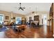 Bright living room with fireplace, hardwood floors, ceiling fan, and dining area with a checkered tablecloth at 600 Heather Brite Cir, Apopka, FL 32712