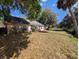 View of the rear of the home and expansive backyard with mature trees at 8040 Equitation Ct, Orlando, FL 32818