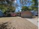 Charming single-story home with mature trees, a two-car garage, and a well-maintained front yard at 8040 Equitation Ct, Orlando, FL 32818