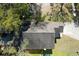 Birds-eye view of the home's roof, with a tree-filled yard, driveway, and nearby parked car at 9329 Dearmont Ave, Orlando, FL 32825