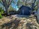 Backyard area showing an outbuilding with a small patio and a fenced yard, shaded by mature trees at 9329 Dearmont Ave, Orlando, FL 32825