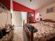 Bedroom with a bed, wood furniture, an exterior door and a bright red accent wall at 9329 Dearmont Ave, Orlando, FL 32825