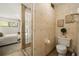 Bathroom with glass block shower, patterned wall, and doorway leading into the bedroom at 1000 Winderley Pl # 237, Maitland, FL 32751
