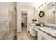Bright bathroom featuring double sinks, neutral decor, glass enclosed shower, and a walk-in closet at 1000 Winderley Pl # 237, Maitland, FL 32751