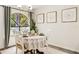 Cozy dining room with a round table, white chairs, modern lighting, and an arched window at 1000 Winderley Pl # 237, Maitland, FL 32751
