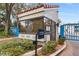 Sun Bay Club entrance features a modern entry system and guard house with mature landscaping at 1000 Winderley Pl # 237, Maitland, FL 32751