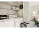 Laundry room with washer, dryer, wire shelving and view to bedroom at 1000 Winderley Pl # 237, Maitland, FL 32751