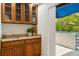 Wet bar boasts granite countertops, wood cabinets, a sink, and access to the outdoor balcony at 1000 Winderley Pl # 237, Maitland, FL 32751