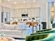 Open-concept kitchen featuring stainless steel appliances, gray cabinets, and bar seating with leather chairs at 10012 Voyager Way, Orlando, FL 32821