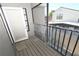 Balcony view featuring a sliding glass door, wooden floor, metal railing and clear plastic sheeting to provide added privacy at 1009 Troon Trce, Winter Springs, FL 32708