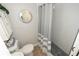 A full bathroom featuring a walk-in shower with gray tile, decorative mirror, and leafy decor at 1009 Troon Trce, Winter Springs, FL 32708