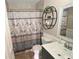 Cozy bathroom featuring a stylish vanity, decorative shower curtain, and a circular decorative shelving unit at 1009 Troon Trce, Winter Springs, FL 32708