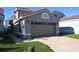 View of a home showcasing the garage, red tile roof, and front lawn at 1009 Troon Trce, Winter Springs, FL 32708