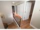 Second floor hallway features wood laminate floors, black stair railing, neutral paint, and closet storage at 1009 Troon Trce, Winter Springs, FL 32708
