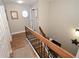 Hallway features hardwood floors, round window accent, staircase with wooden railing, and neutral paint palette at 1009 Troon Trce, Winter Springs, FL 32708